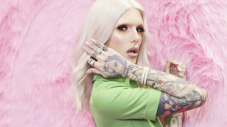 Jeffree Star posing in front a pink fur wall