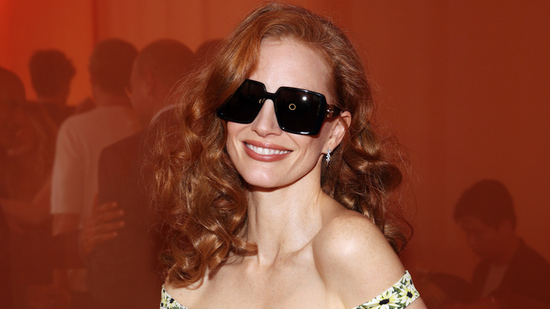 Jessica Chastain smiling while wearing sunglasses.