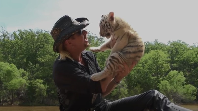 Joe exotic outside, holding tiger cub