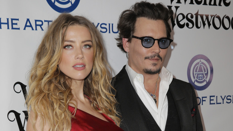 Amber Herd & Johnny Depp posing together at an event