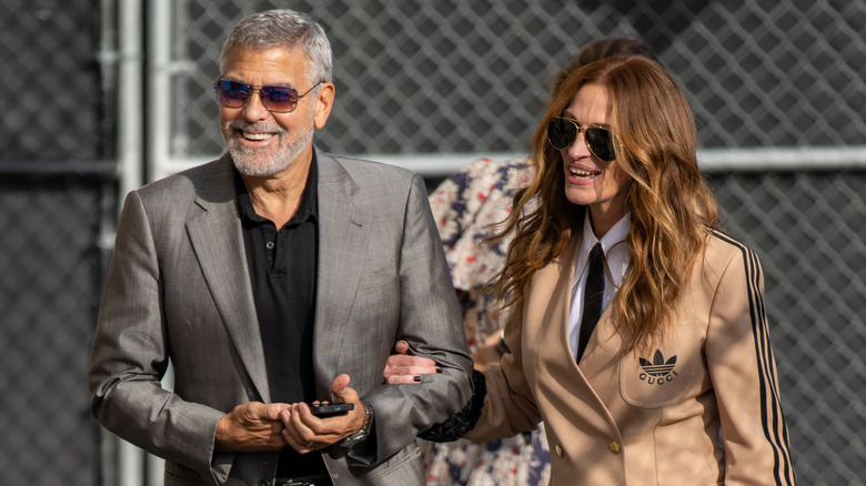 Julia Roberts walks arm in arm with George Clooney.