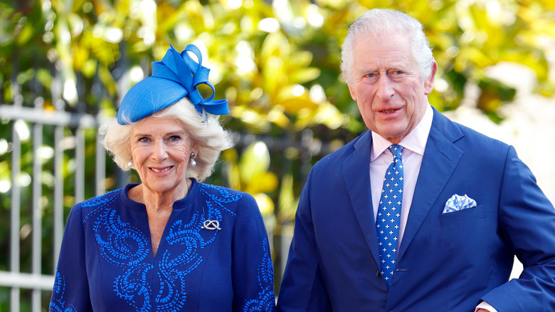 King Charles and Queen Camila walking dressed in blue