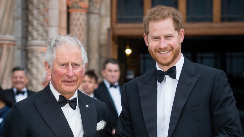 King Charles III and Prince Harry posing for photos