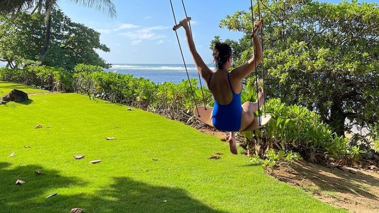 Kourtney Kardashian on an outdoor swing