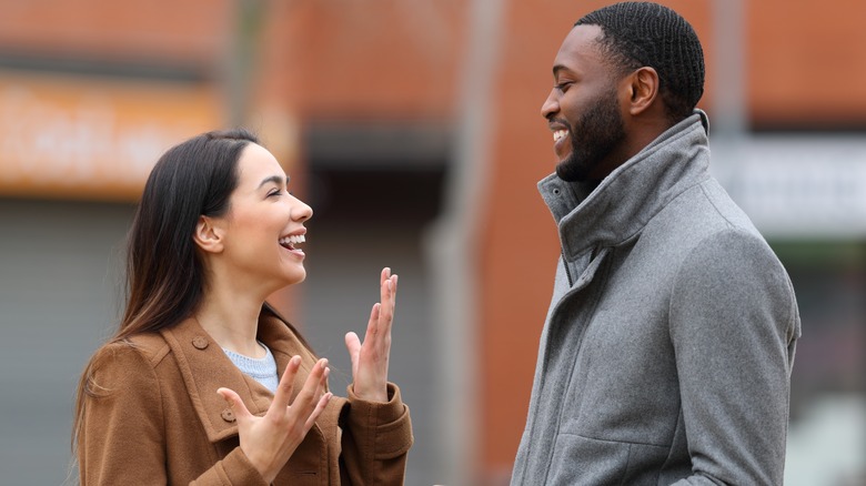 man smiling at woman talking