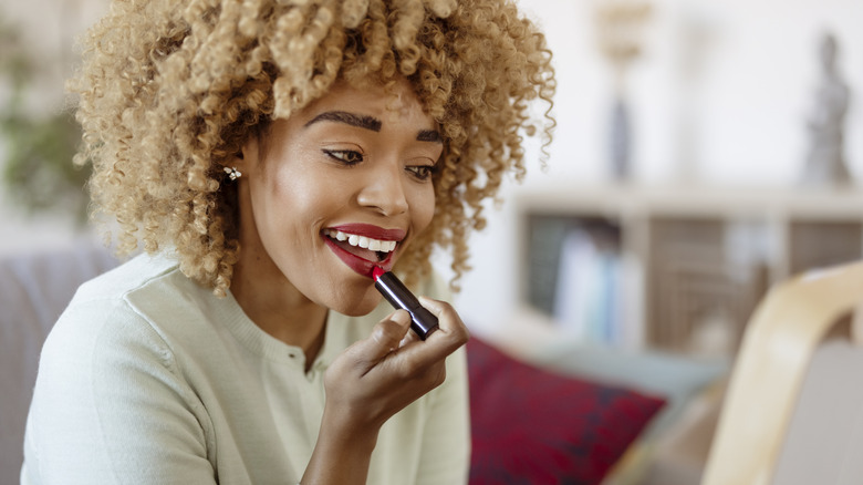 Woman applying red lipstick