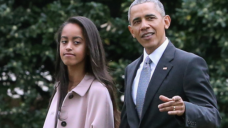 Malia and Barack Obama walk side by side