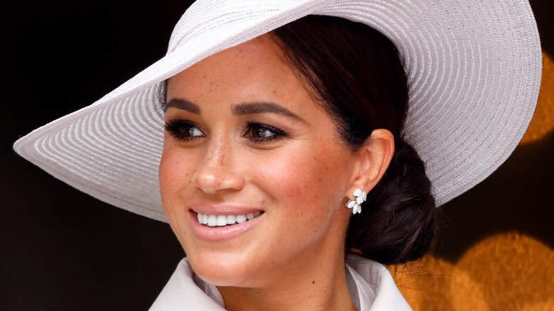 Meghan Markle smiling in a big hat