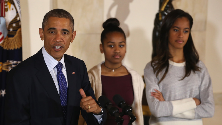 Malia and Sasha listen to Barack's speech