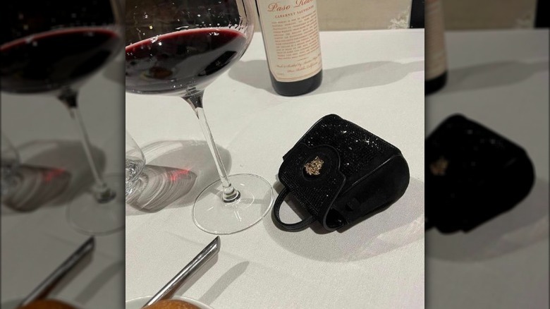 Versace Medusa mini bag next to wine glass