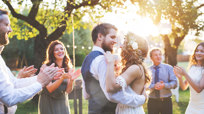 Married couple dancing surrounded by friends