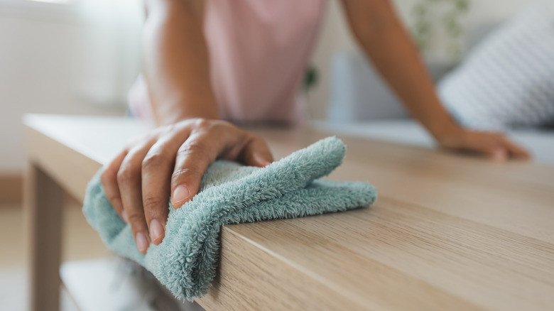 Woman cleaning surface with rag