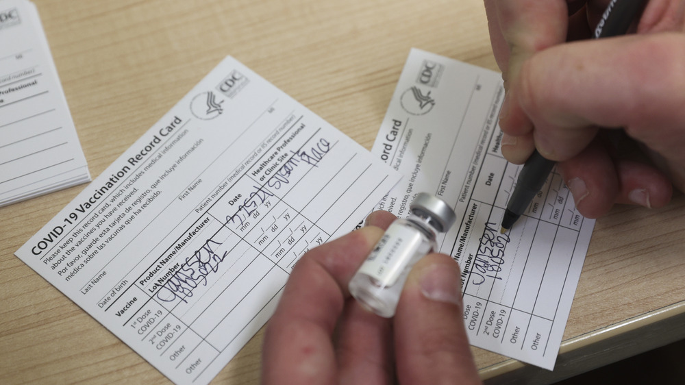 Person signing a vaccination card