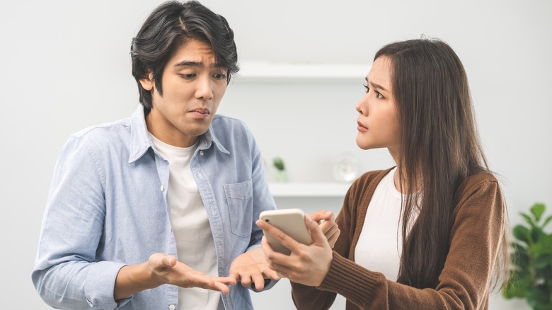 Couple arguing over something on a phone screen