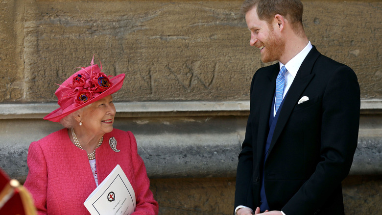 Queen Elizabeth and Prince Harry smiling at each other