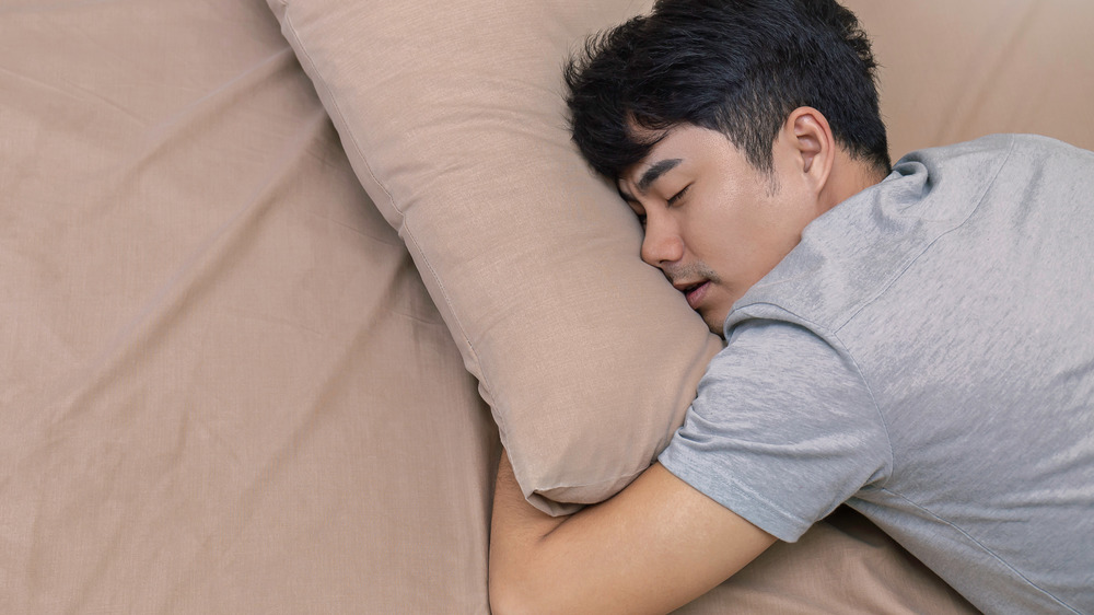 Man sleeping on tan bedding