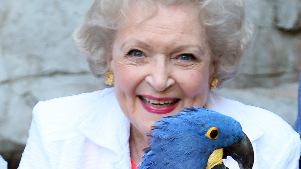 Betty White smiling with blue macaw parrot