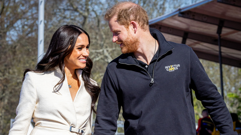 Meghan Markle and Prince Harry smiling at each other at the Invictus Games