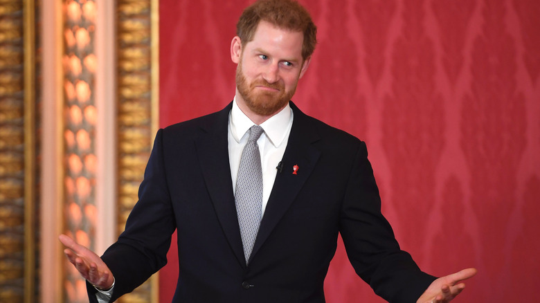 Prince Harry holds up his hands 