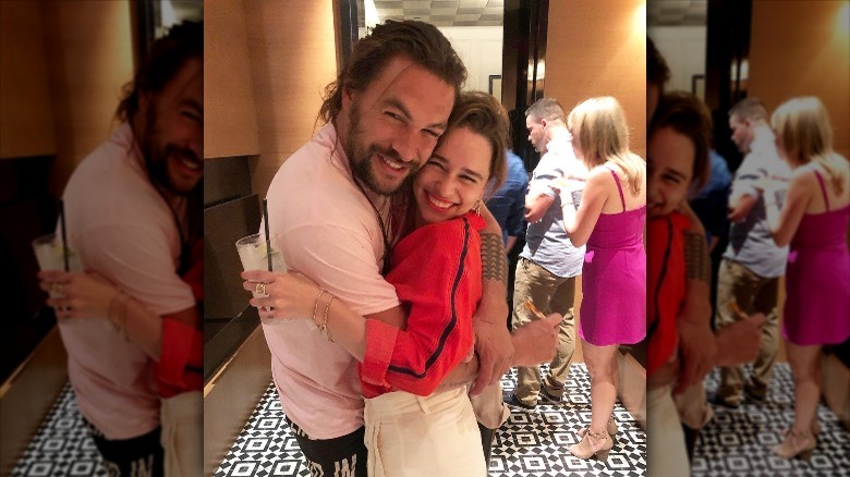 Emilia Clarke and Jason Momoa hug each other