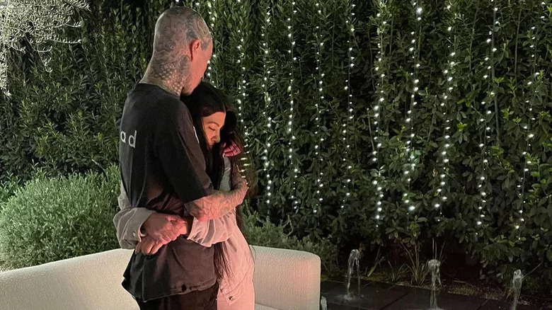 Kourtney Kardashian and Travis Barker cuddle.