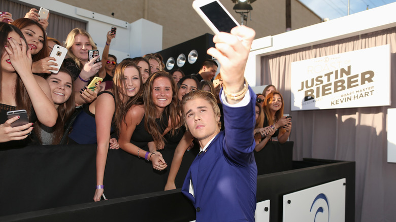 Justin Bieber taking photos with his fans