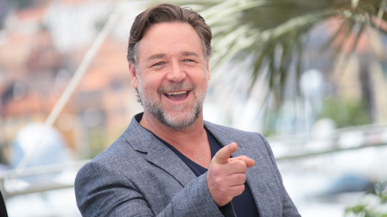 Grinning Russell Crowe pointing at cameras