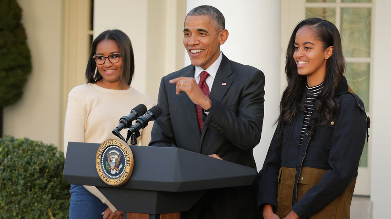 Malia and Sasha Obama laughing with their dad