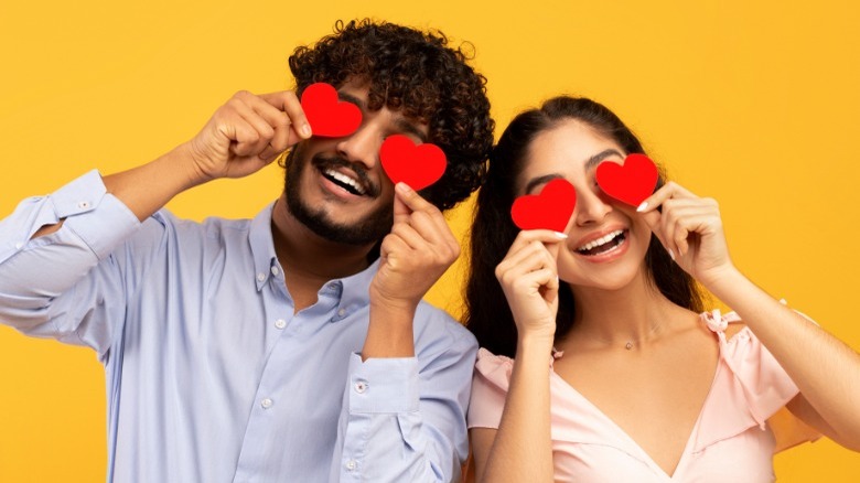 couple holding paper hearts