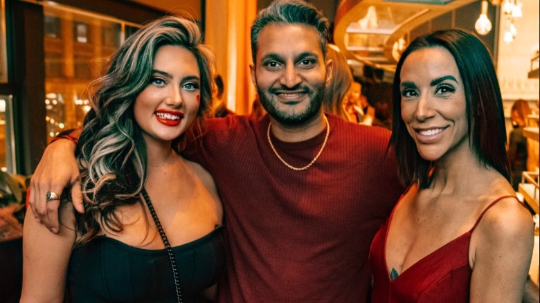 Shake Chatterjee posing with two women at party 