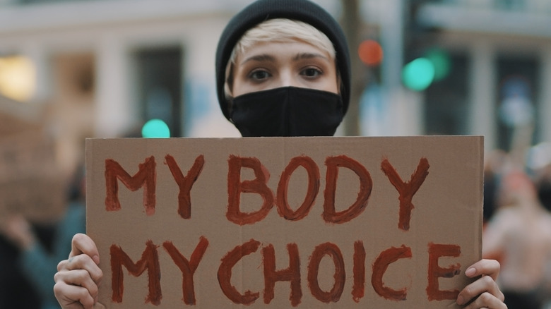 person holding sign saying my body my choice