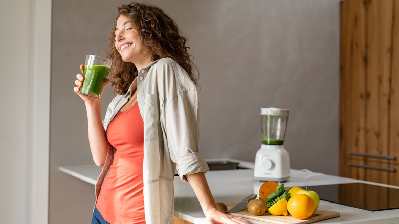 woman drinking green juice