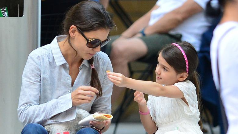 Young Suri offers Katie a bite