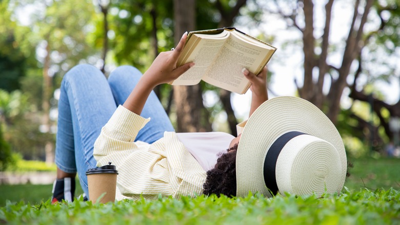 Woman reading book in grass 