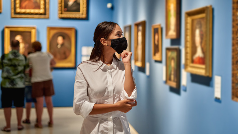 Woman at art museum looking at paintings 