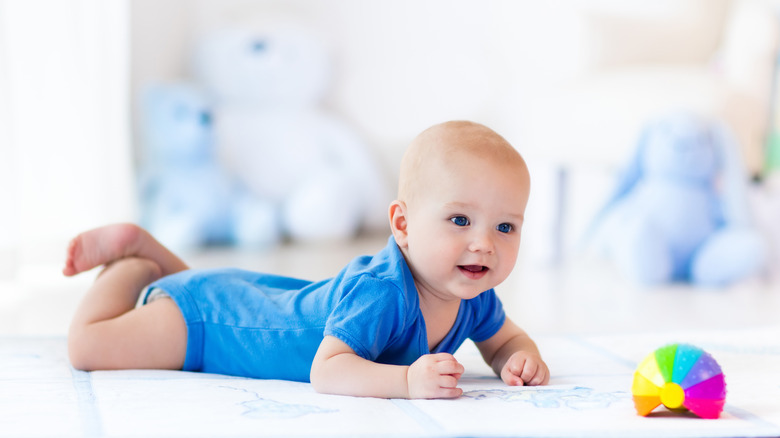 Baby on blanket with toy