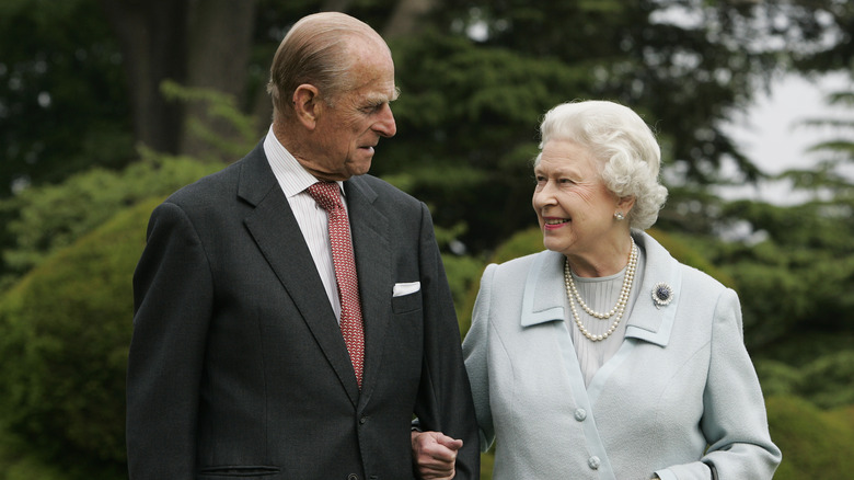 Queen Elizabeth and Prince Philip walking and looking at each other