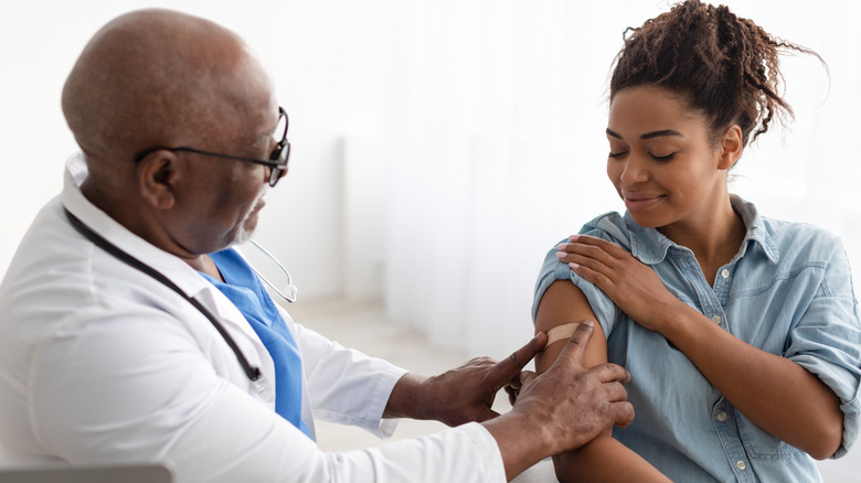 A doctor applying a band-aid to patient's arm