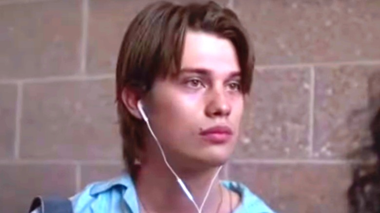 Nicholas Galitzine wearing blue shirt with earbuds in Chambers