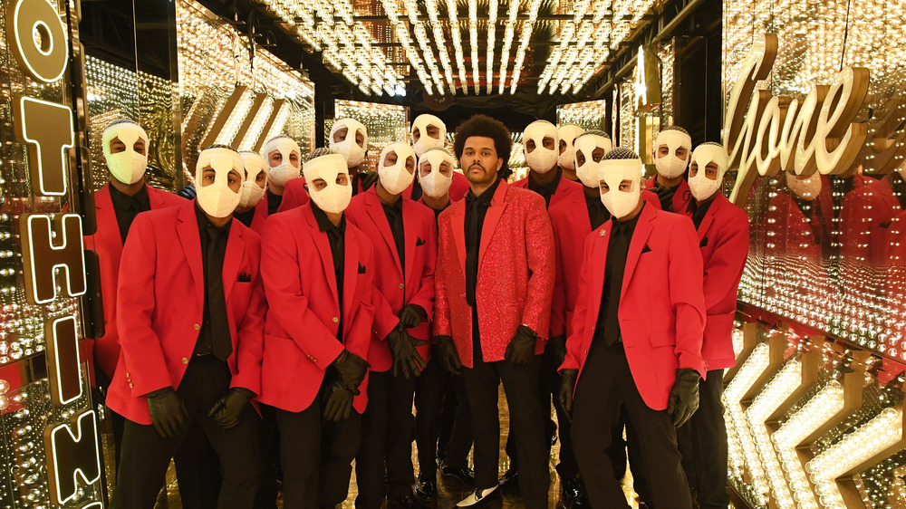 The Weeknd with bandaged backup dancers in red jackets 