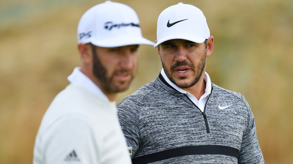 Dustin Johnson and Brooks Koepka talking on the green