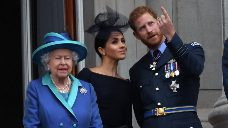 Meghan Markle stands with Prince Harry and the queen