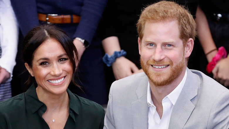 Meghan Markle and Prince Harry sitting and smiling