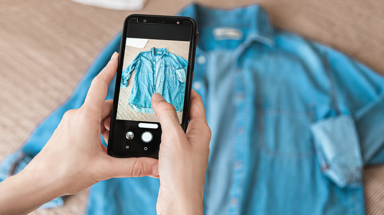 person taking a photo of a denim shirt