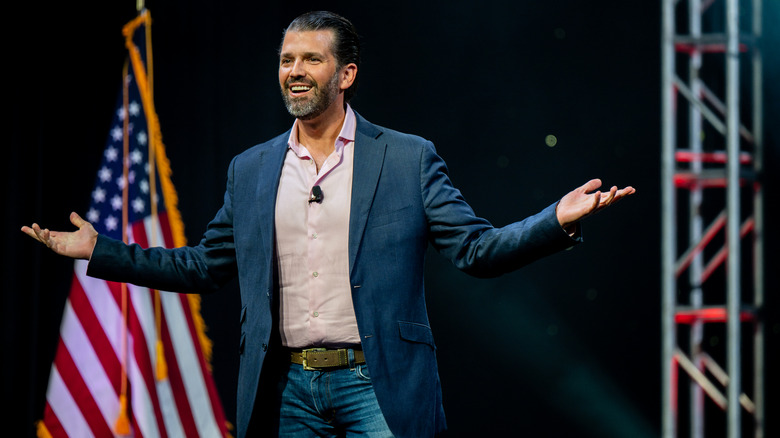 Donald Trump Jr. on stage in front of American flag