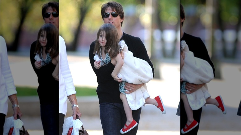 Tom Cruise carrying a young Suri Cruise