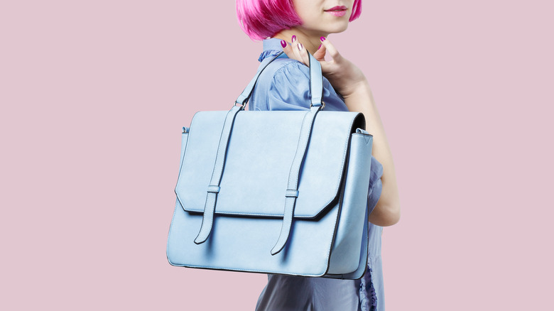 A woman wearing a blue dress and carrying a blue bag 