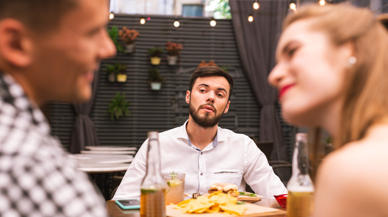 man observing couple smiling at each other