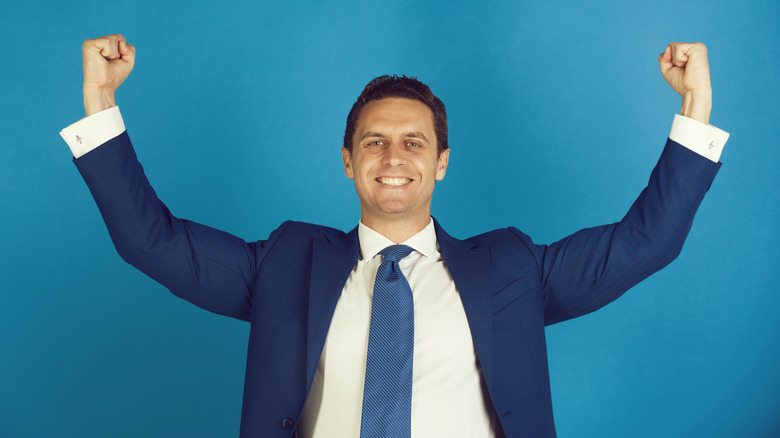 businessman smiling with arms raised