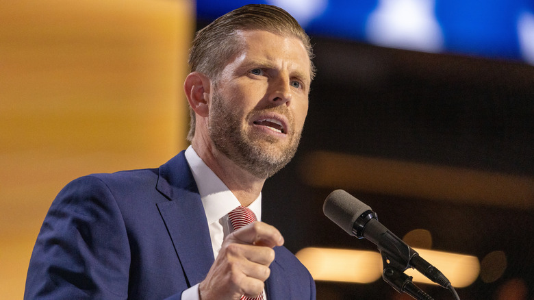 Eric Trump speaking in front of a mic at an event